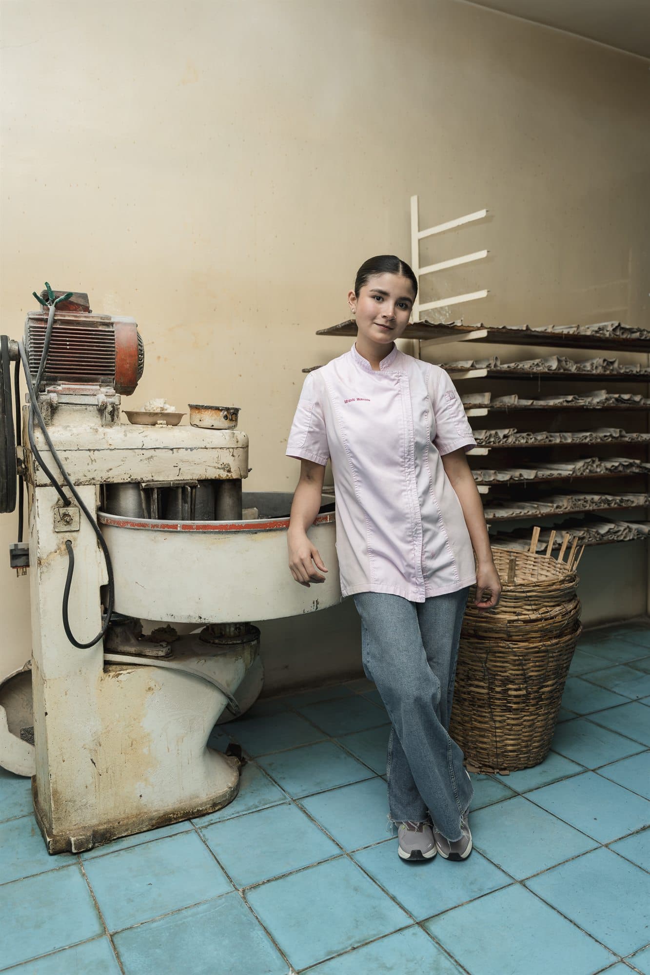 Miranda junto a una amasadora industrial en una panadería tradicional