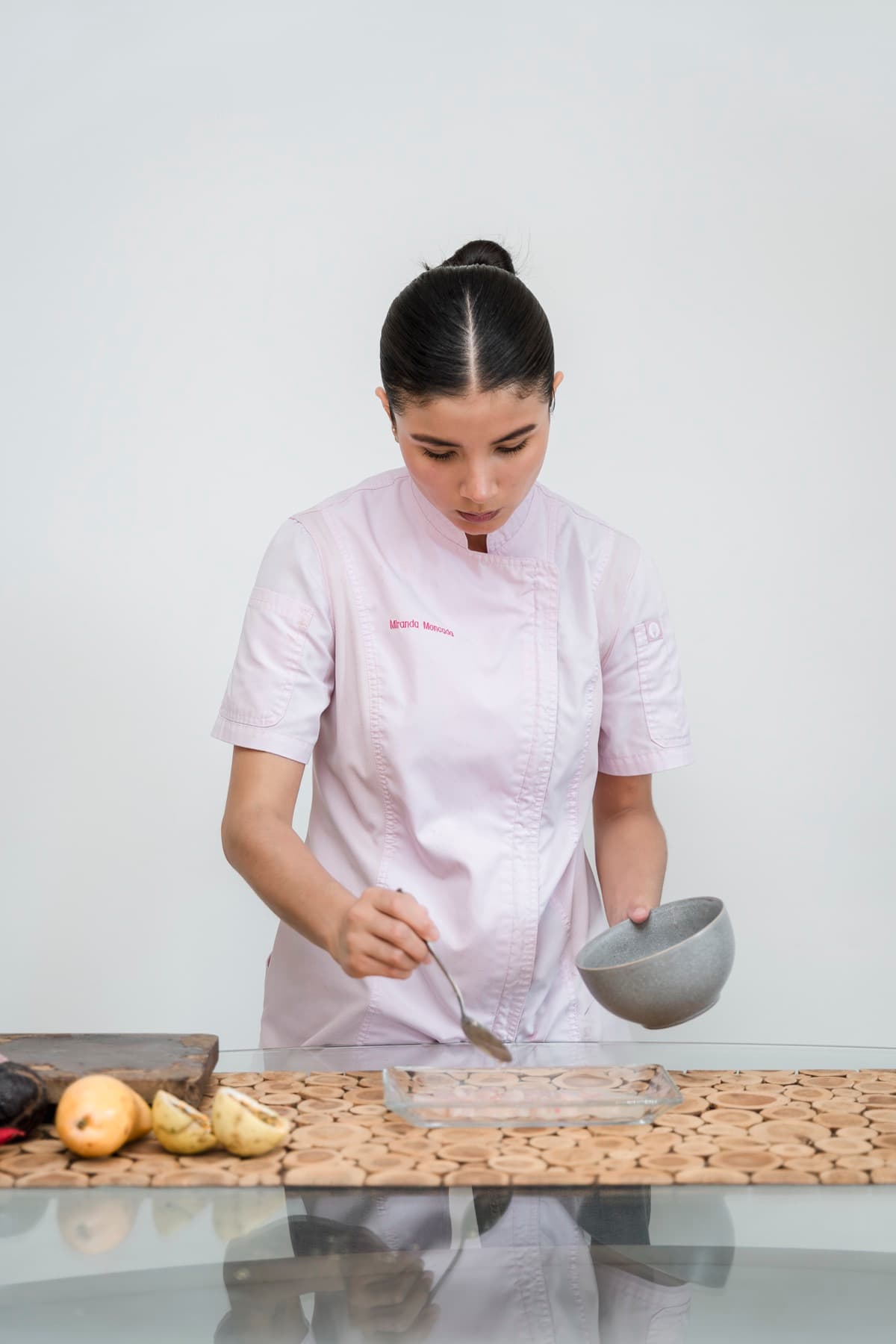 Miranda Moncada emplatando con una cuchara sobre una mesa de cristal, con filipina rosa