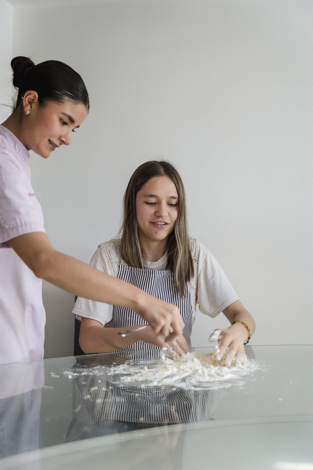 Dos personas preparando pasta juntas durante una experiencia de cocina